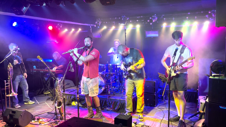 Big Signature performing live under colorful stage lights
