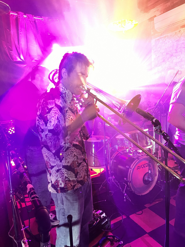 Big Signature horn player performing live in saturated stage light
